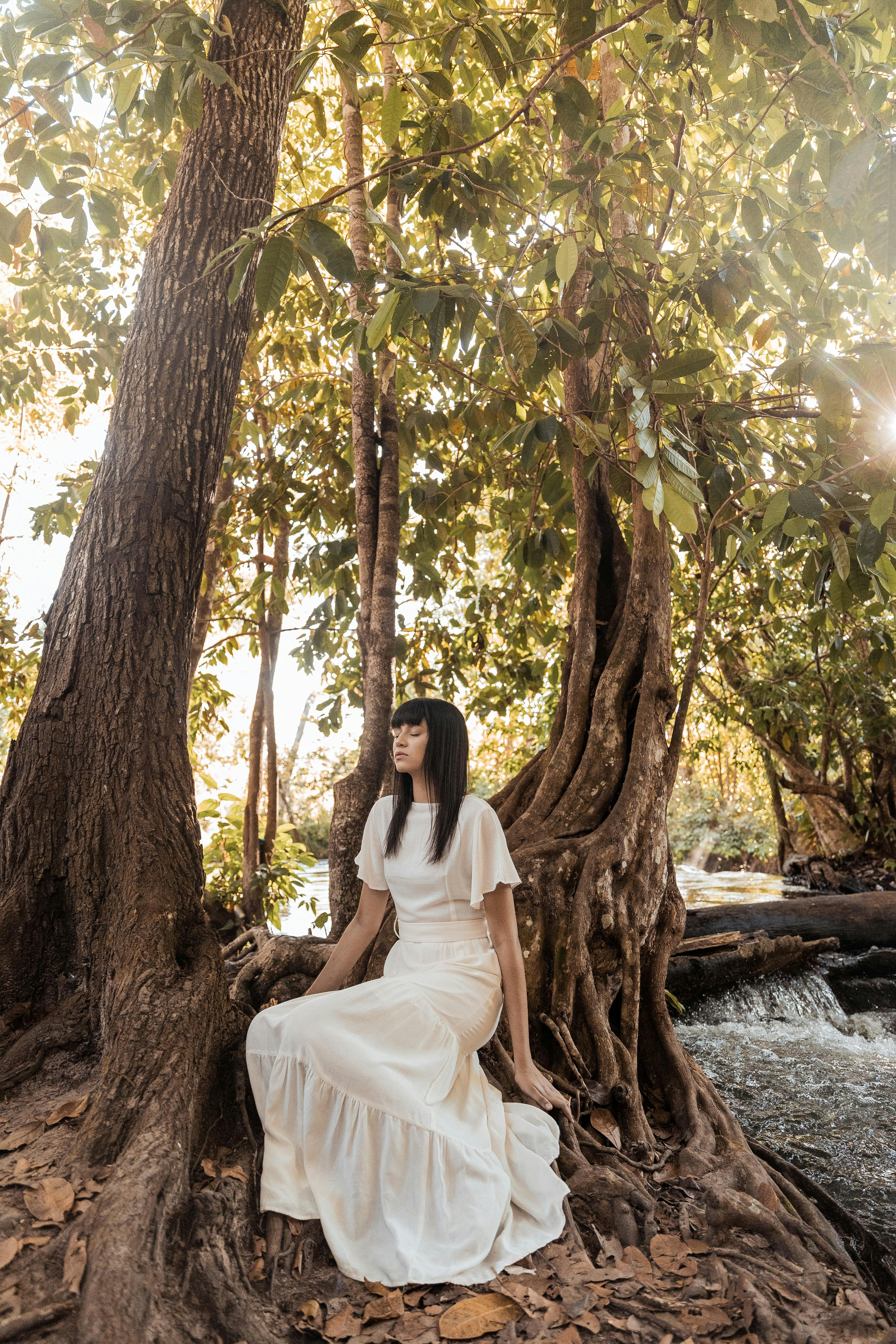 woman in white dress sitting on brown ...